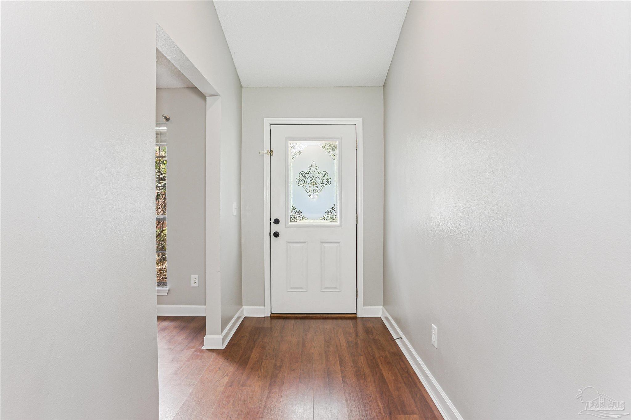 1062 Joaquin Road Pensacola, FL 32506 - Photo 6 of 42 an empty room with wooden floor and windows
