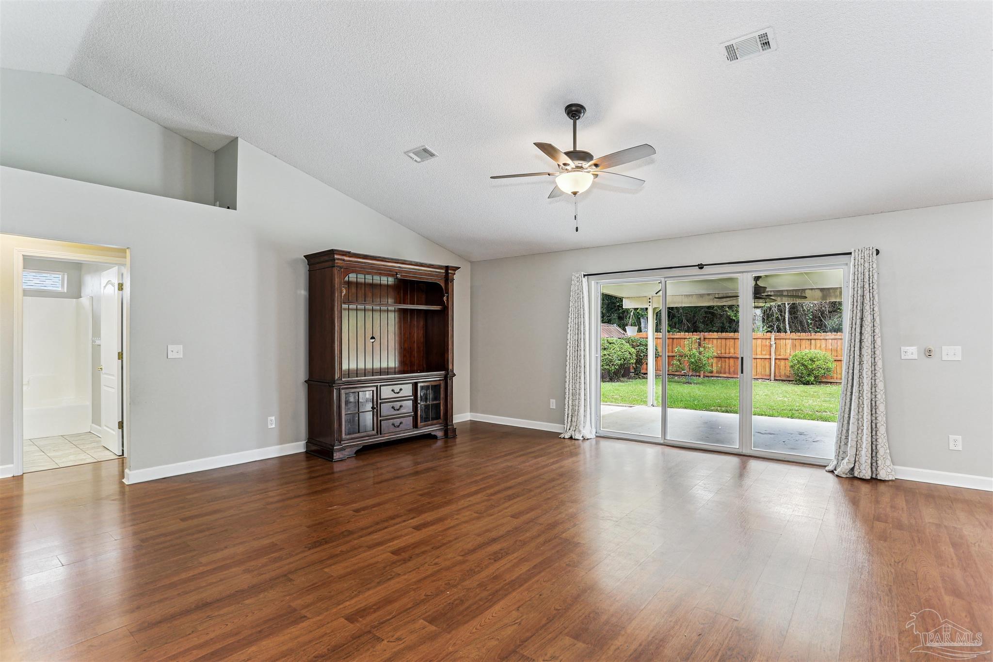 1062 Joaquin Road Pensacola, FL 32506 - Photo 9 of 42 a view of an empty room with a window and wooden floor