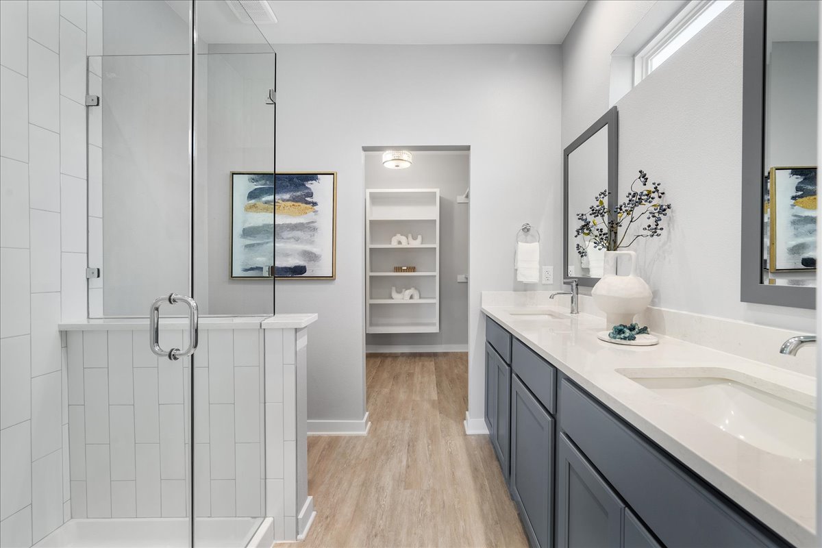 1149 Ebert Avenue, Unit D Austin, TX 78721 - Photo 14 of 34 Full bathroom featuring a walk in closet, a shower stall, light wood-style floors, and double vanity