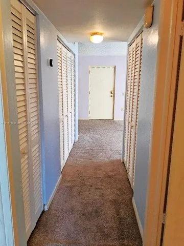a view of a hallway with wooden floor and entryway