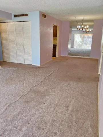 a view of an empty room with a chandelier