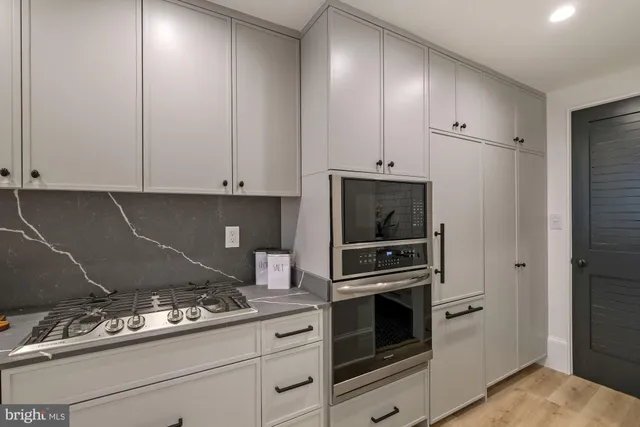 a kitchen with white cabinets and appliances