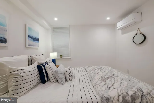 a bedroom with a bed and table with white walls