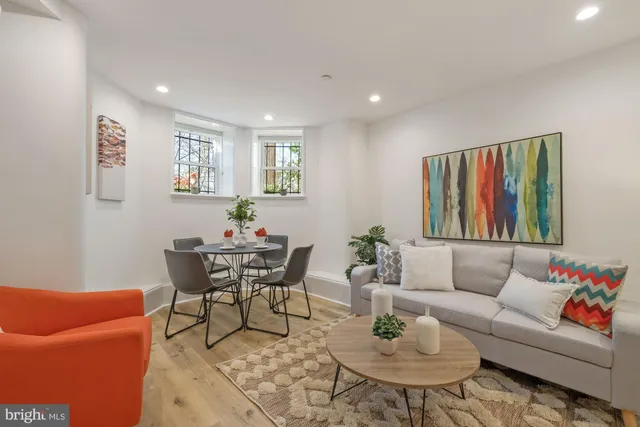 a living room with furniture and a wooden floor