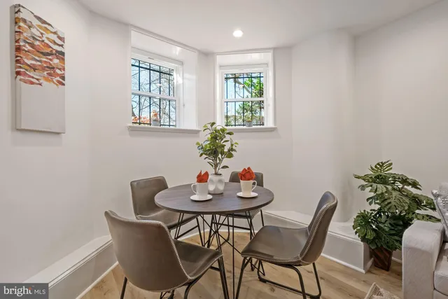 a dining room with furniture and potted plants