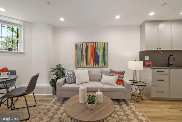 a living room with furniture and a wooden floor