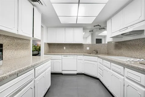 a kitchen with white cabinets and white appliances