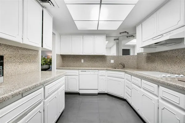 a kitchen with white cabinets and white appliances
