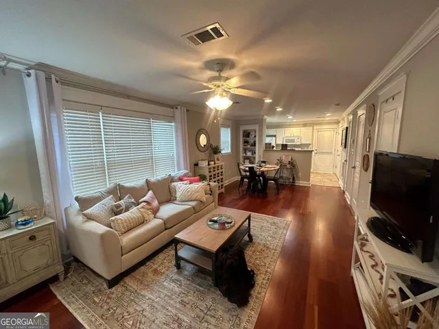 a living room with furniture flat screen tv and a large window