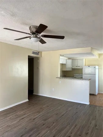 a view of room with wooden floor and ceiling fan