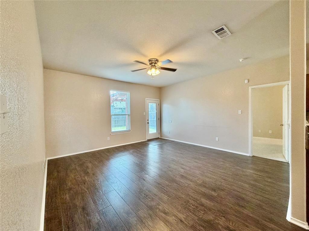 5817 Deck House Road Fort Worth, TX 76179 - Photo 3 of 19 Spacious room featuring rich wood-finish flooring, a ceiling fan with integrated lighting, and neutral wall tones