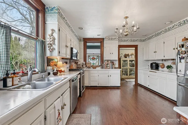 a large white kitchen with stainless steel appliances