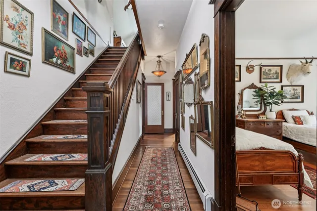 a view of staircase with lots of frames on wall and a rug