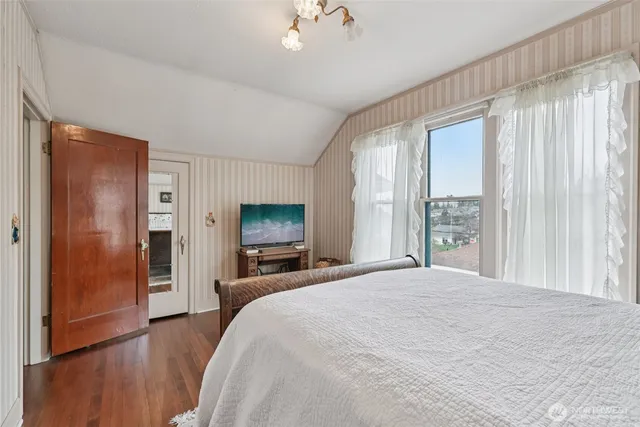 a bedroom with a bed and a flat tv screen on dresser