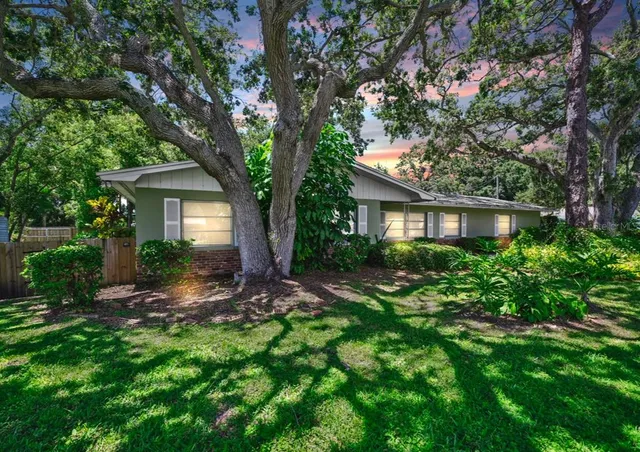 a view of a house with yard and tree s