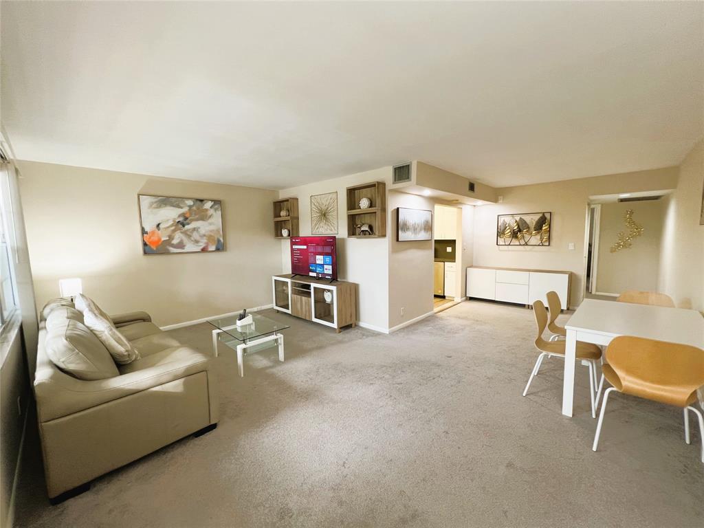 1902 Bermuda Circle, Unit H2 Coconut Creek, FL 33066 - Photo 3 of 32 a living room with furniture and a dining table with projector