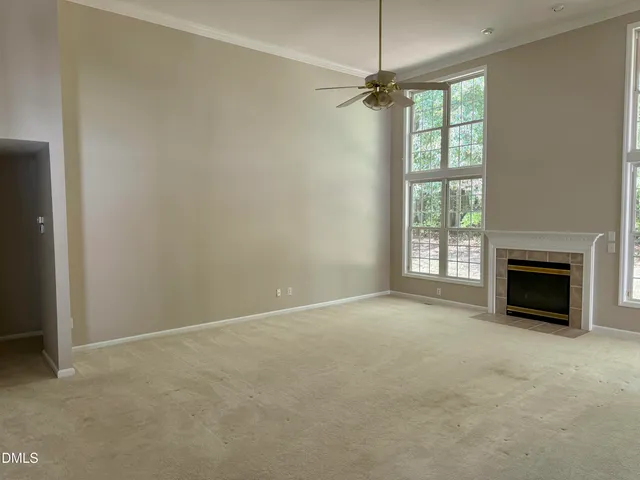 an empty room with windows fireplace and windows