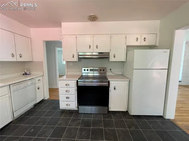 a kitchen with a stove a refrigerator and a sink