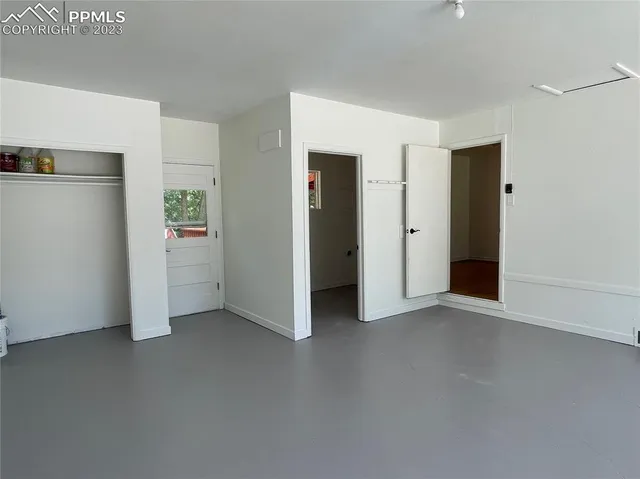 an empty room with closet and windows