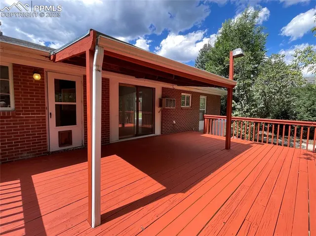 a view of house with backyard and deck