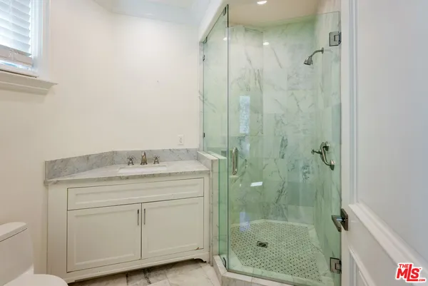 a kitchen with kitchen island stainless steel appliances a sink a counter top space cabinets and wooden floor