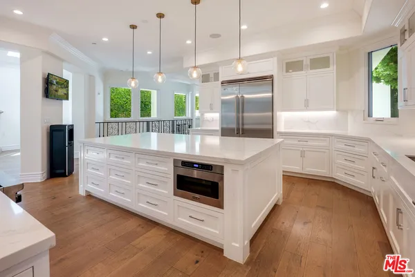 a view of an empty room with wooden floor and a fireplace