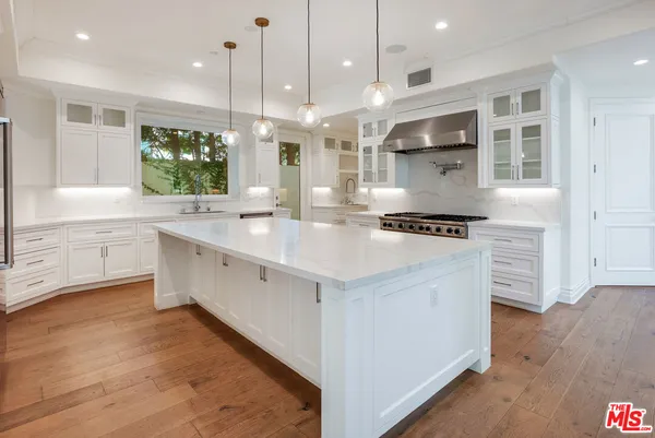 a view of a white house with a yard table and chairs