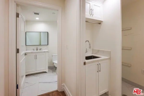 a view of an empty room with wooden floor fireplace and a window