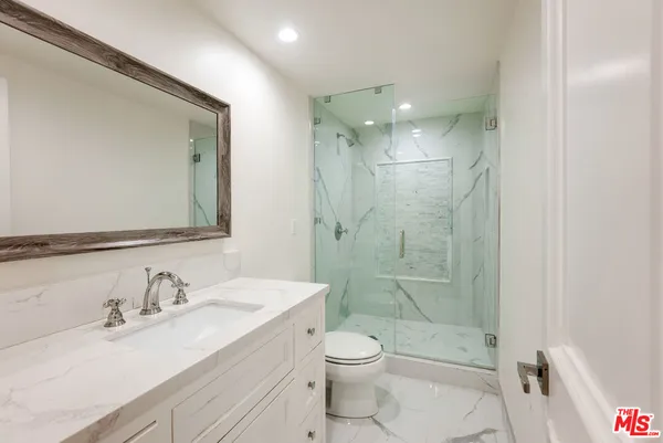 a bathroom with a granite countertop sink mirror and a bath tub