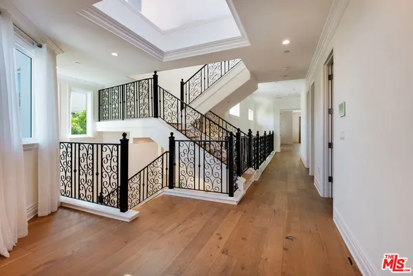 a view of empty room with wooden floor and windows