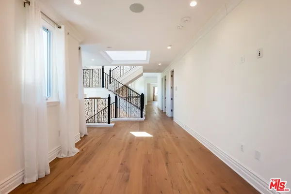 a bathroom with a toilet a sink a glass door a shower and a mirror