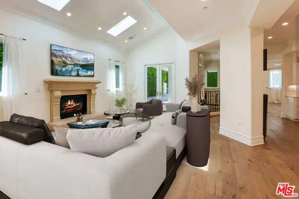 a view of an empty room with chandelier and a chandelier fan