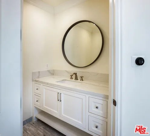 a bathroom with a granite countertop sink a mirror and a shower