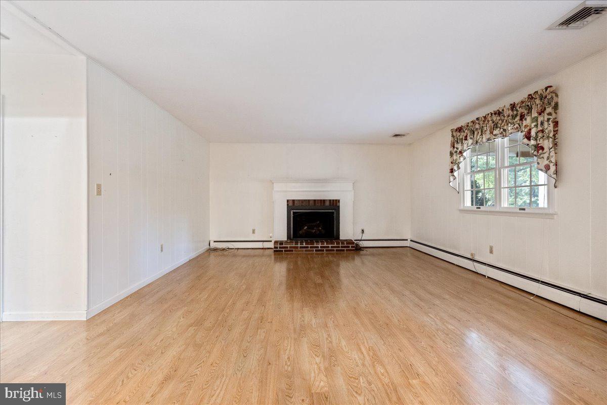 46 Hickory Lane Chalfont, PA 18914 - Photo 12 of 36 an empty room with wooden floor and fireplace