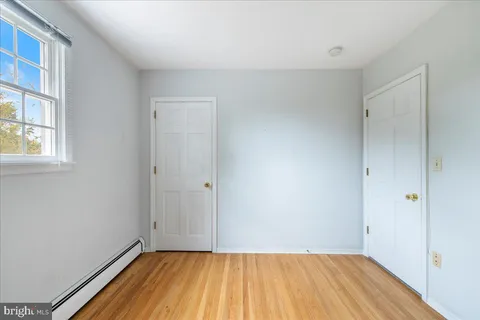 a view of a room with wooden floor and a window
