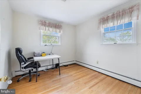 a workspace with wooden floor and a window