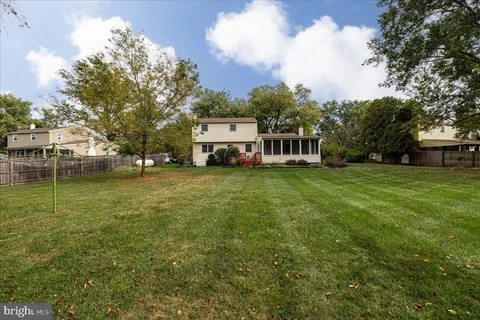 a view of a house with a big yard and large trees