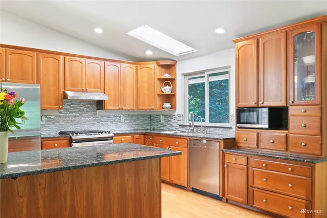 a kitchen with granite countertop wooden cabinets a sink and a window