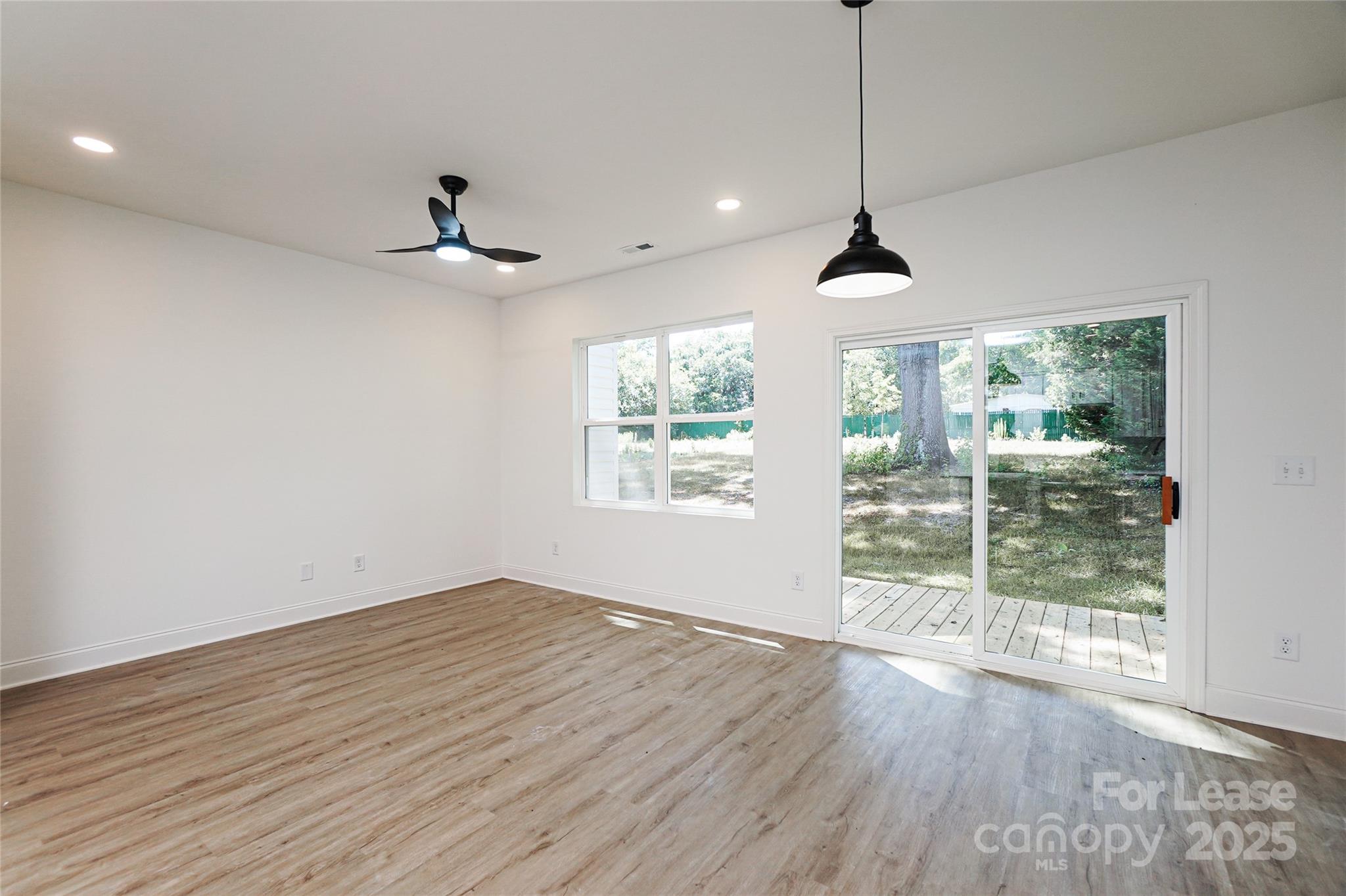 3222 Sam Wilson Road Charlotte, NC 28214 - Photo 11 of 31 a view of an empty room with wooden floor and a window