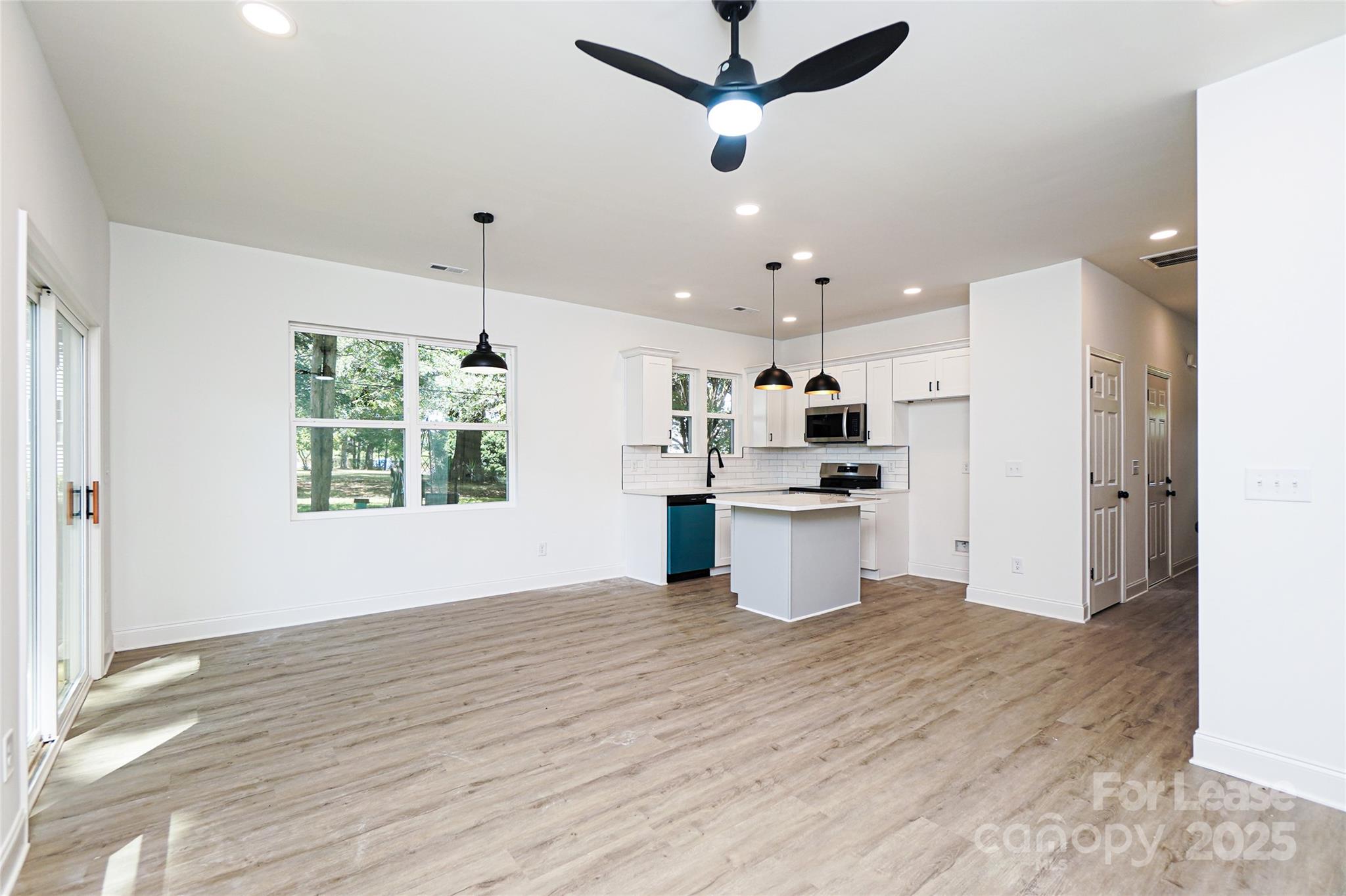 3222 Sam Wilson Road Charlotte, NC 28214 - Photo 12 of 31 a view of a kitchen with kitchen island wooden floor and stainless steel appliances