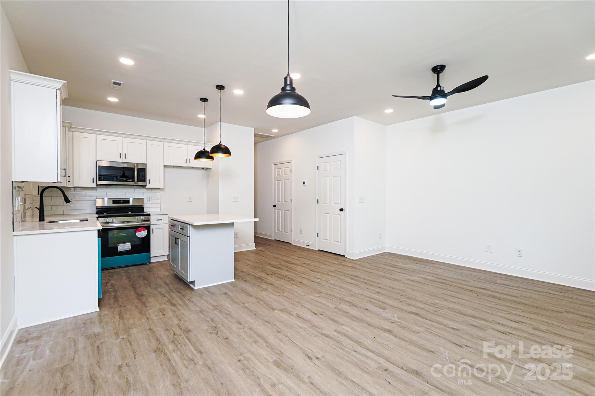 3222 Sam Wilson Road Charlotte, NC 28214 - Photo 13 of 31 a kitchen with a refrigerator a stove top oven a sink and dishwasher with wooden floor