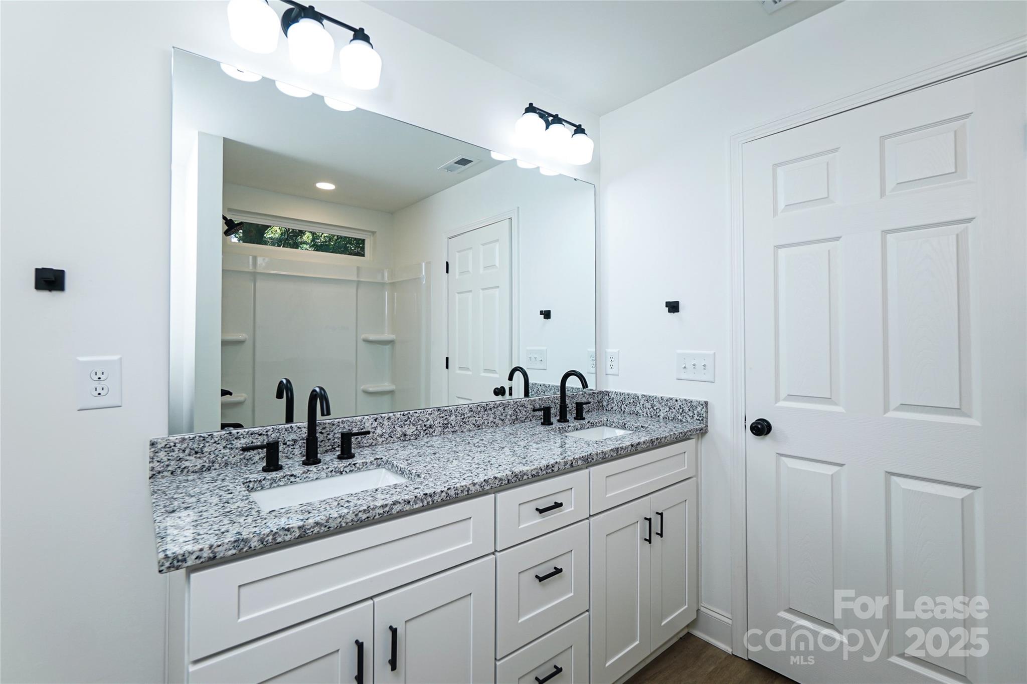 3222 Sam Wilson Road Charlotte, NC 28214 - Photo 18 of 31 a bathroom with a granite countertop double vanity sink and mirror
