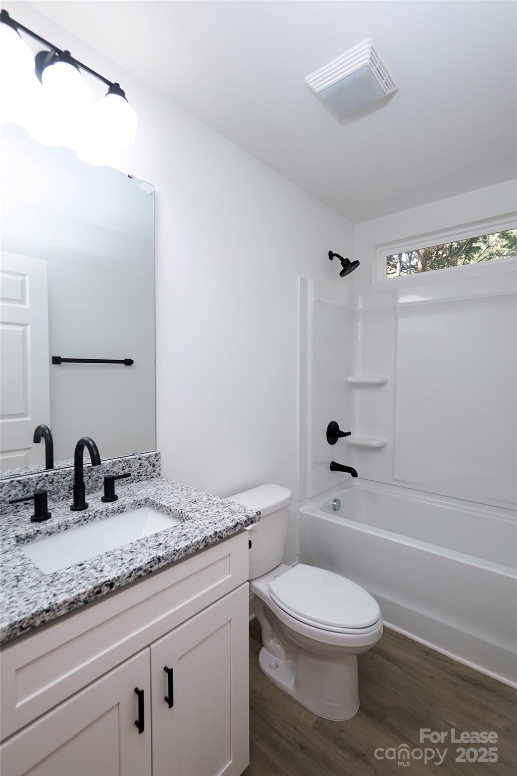 3222 Sam Wilson Road Charlotte, NC 28214 - Photo 20 of 31 a bathroom with a granite countertop toilet a sink and a mirror