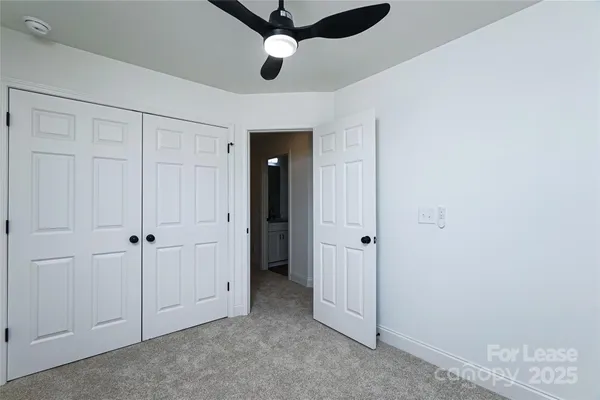 an empty room with chandelier fan