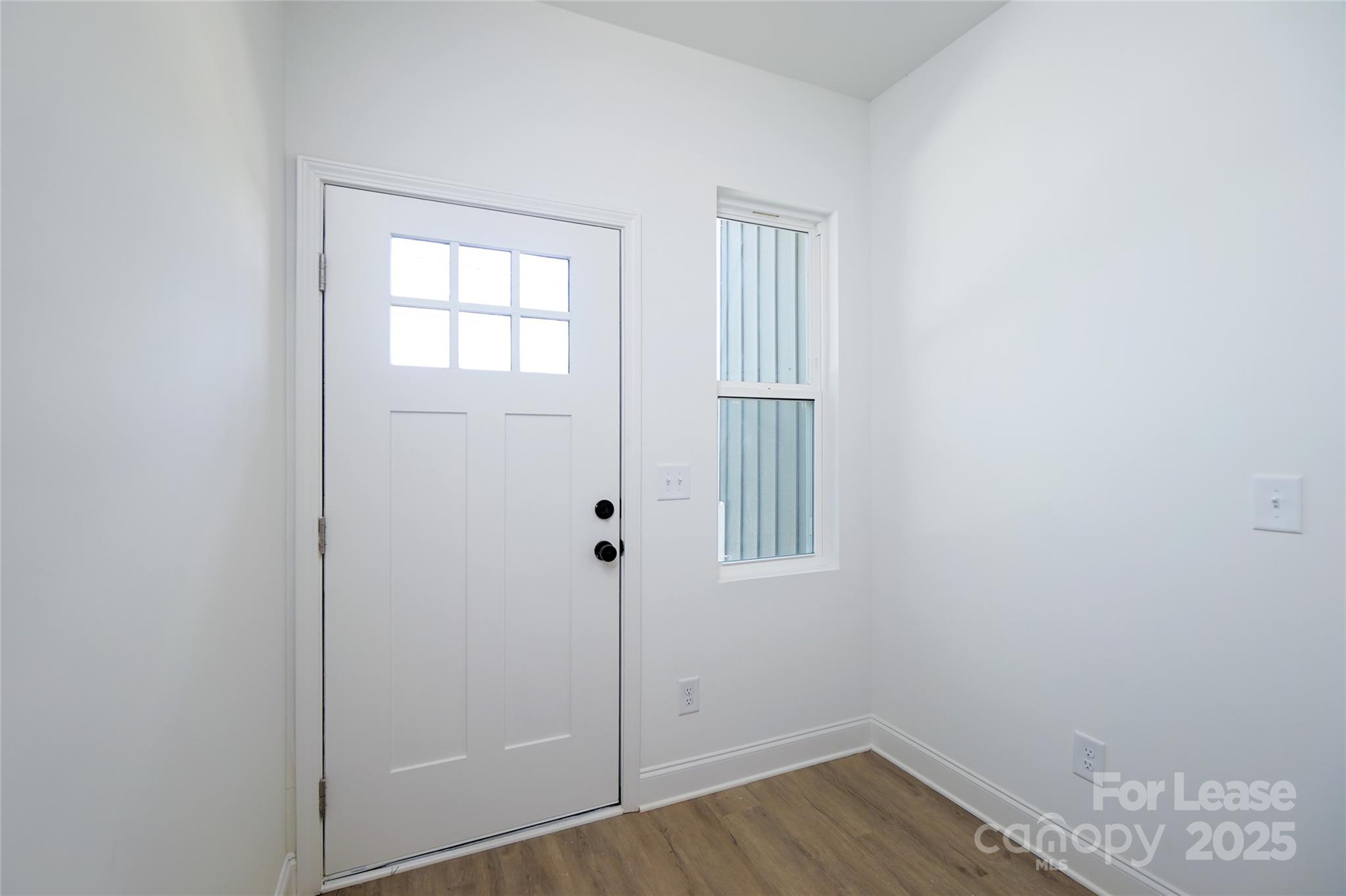 3222 Sam Wilson Road Charlotte, NC 28214 - Photo 3 of 31 an empty room with wooden floor and windows