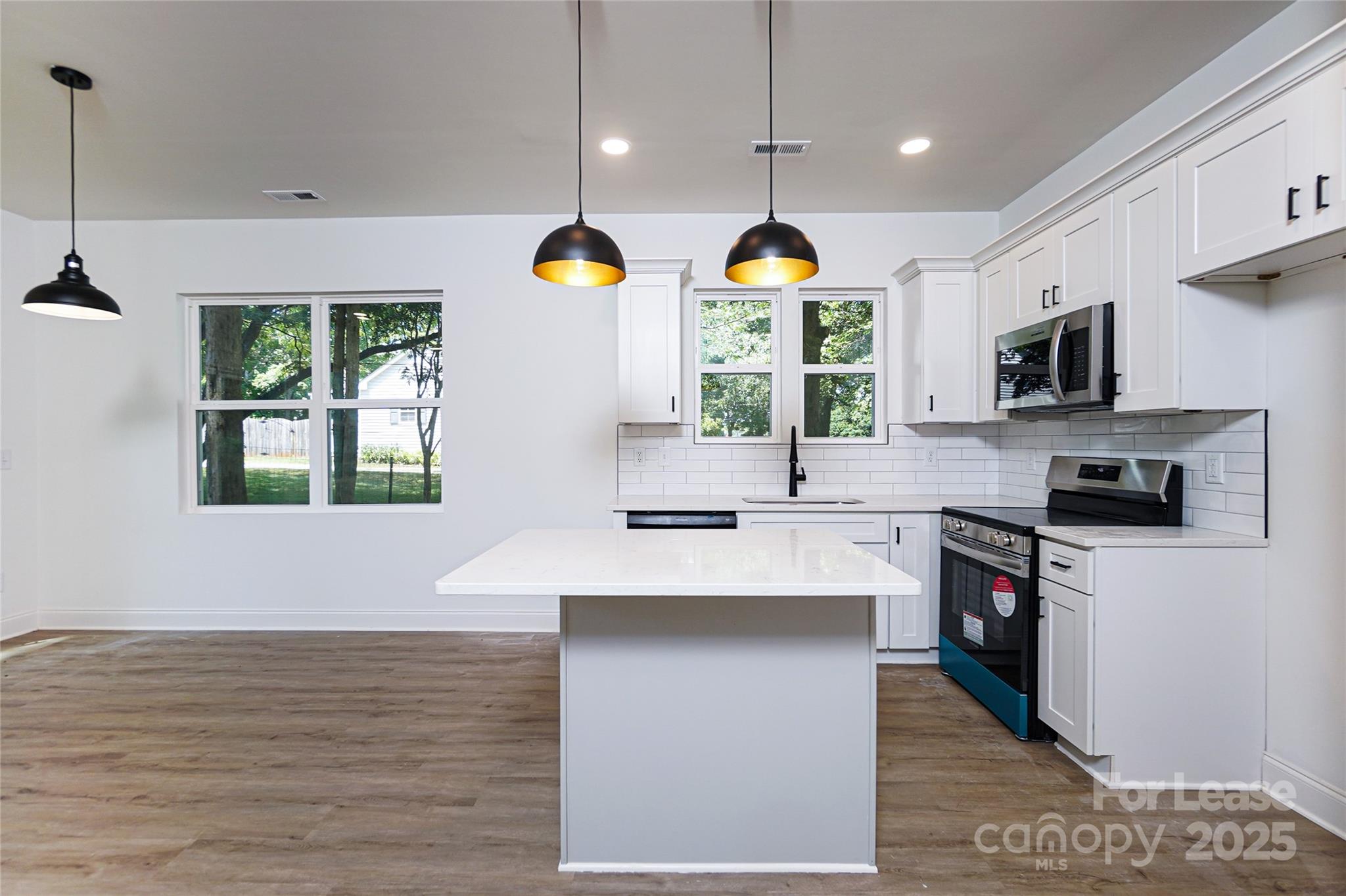 3222 Sam Wilson Road Charlotte, NC 28214 - Photo 7 of 31 a kitchen with stainless steel appliances granite countertop a stove a sink and a microwave