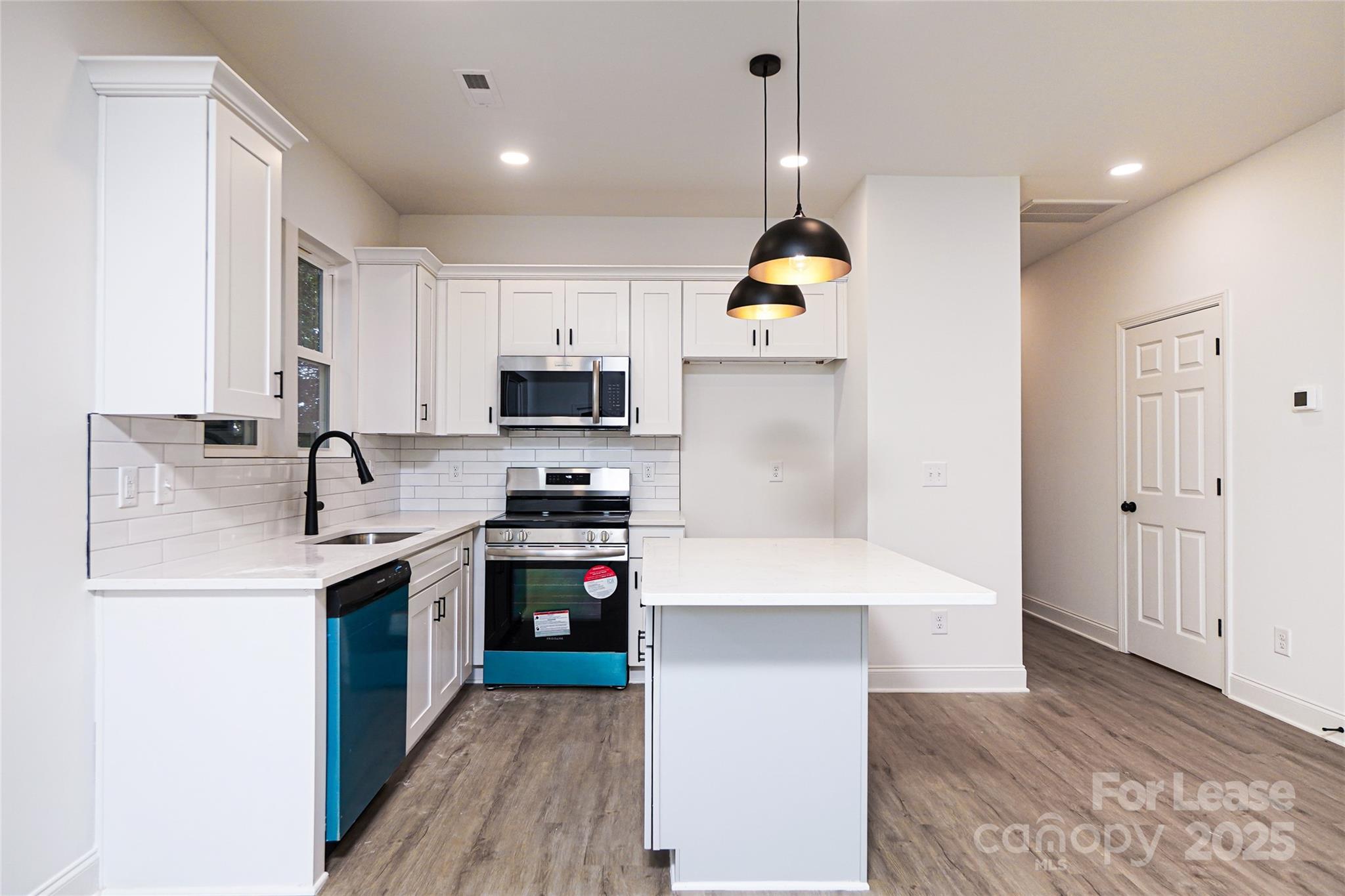 3222 Sam Wilson Road Charlotte, NC 28214 - Photo 8 of 31 a kitchen with stainless steel appliances kitchen island a sink a stove and a refrigerator