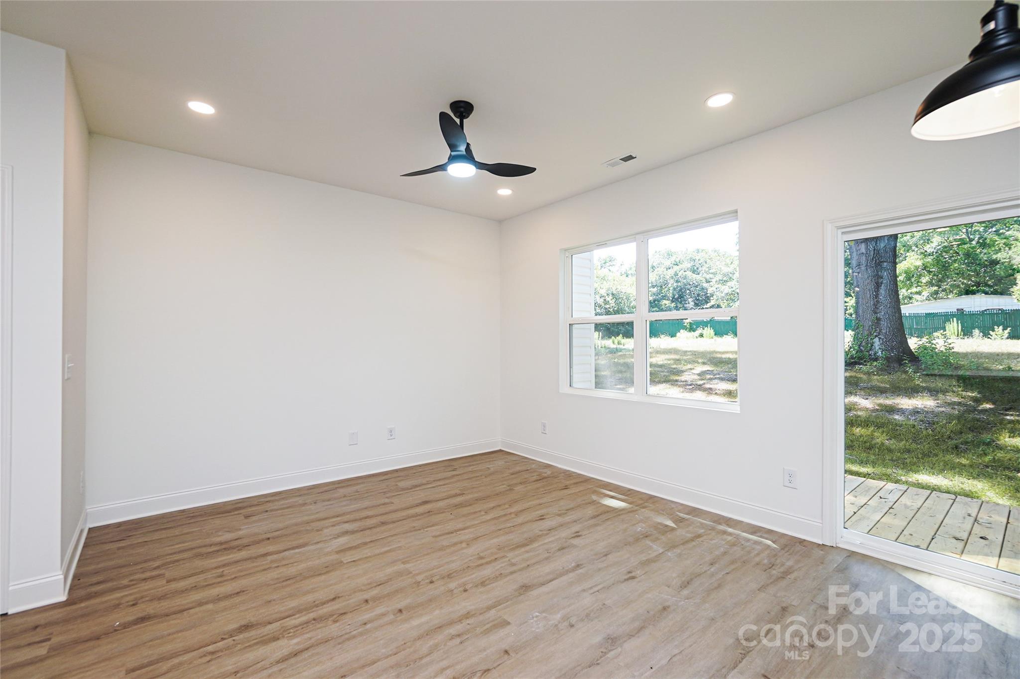 3222 Sam Wilson Road Charlotte, NC 28214 - Photo 10 of 31 a view of an empty room with wooden floor and a window