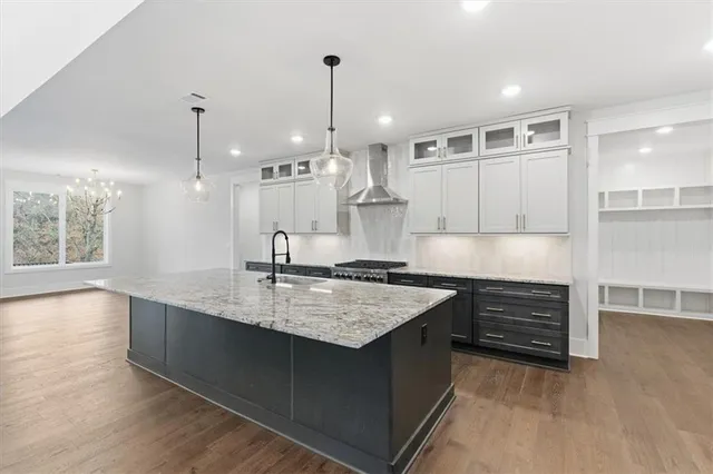 a kitchen with a sink stove and wooden floor