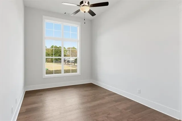 an empty room with a window and a fan